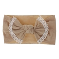 Detail showing soft nylon baby headband with lace-edged bow in light brown color - Nude