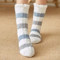 White coral fleece floor socks with blue and grey stripes worn on a woven carpet - Blue & Grey Striped