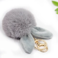 Dettaglio di un portachiavi in peluche grigio con orecchie di coniglio e gancio dorato - Pompon 8cm + Orecchie di coniglio / Grigio