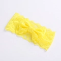 Macro shot of yellow lace fabric texture and bow detail on the baby girls headband - Yellow