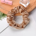 Detail of brown velvet scrunchie on wooden tray with cozy lifestyle accessories - Khaki