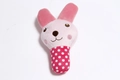 Detailed view of plush pink rabbit rattle toy with a red polka dot pattern handle - Rabbit Stick