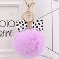 Close-up of purple faux fur pompom keychain with marble pattern bow and gold D-ring - Taro Purple