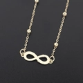 Gouden brillenkoord met infinity symbool en metalen kralen op een zwarte achtergrond - Goud