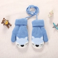 Close-up of blue knitted toddler mittens with fox pattern and neck string on soft fabric - About 3 years old / Blue
