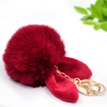 Dettaglio del portachiavi a pompon rosso con orecchie di coniglio e gancio dorato - Pompon 8cm + Orecchie di coniglio / Borgogna