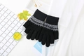 Primer plano de guantes de punto negros con patrón nórdico y puntas táctiles de invierno - Negro