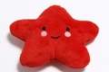 Detail of red plush star dog toy with soft fabric texture and embroidered smiley face - Red Star