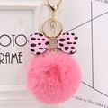 Close-up of fluffy pink faux fur pompom keychain with leopard print bow and sparkling rhinestone - Watermelon red