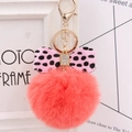 Close-up of pink faux fur keychain with polka dot bow and rhinestone details - Orange Red
