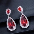 Close-up of teardrop bridal earrings with red pear-cut stones and silver zircon settings - Red