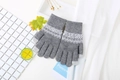 Detalle del tejido de punto en guantes de invierno grises con jacquard y puntas táctiles - Gris Jaspeado Claro