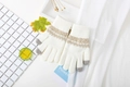 Detalle de guantes de punto con patrón de rombos marrones y puntas táctiles grises - Blanco Suave