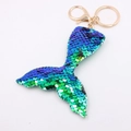 Detail view of a reversible sequin mermaid tail keychain with blue and green flip colors - Mermaid Tail - Rainbow Green