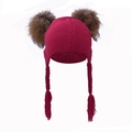 Detail of dark red knit baby hat with earflaps, long braids, and twin brown pom-poms - Burgundy