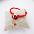 Bracelet en corde rouge avec pendentifs sac porte-bonheur et pièces dorées sur support - Bracelet Gourde Corde Rouge Complète (Pièces Or)