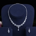 Detailed macro view of silver floral zircon necklace and earrings on blue velvet stand - Platinum Set