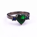 Anello in oro nero con pietra verde a cuore e accenti di zircone blu su sfondo bianco - US 6 / Verde