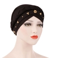 Detail of black turban with braided band and gold flower beads on a model head - Black