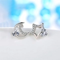 Macro shot of silver crescent moon and star stud earrings with sparkling cubic zirconia - Star Moon White Zircon Asymmetric (JED190)