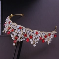 Dettaglio di una tiara da sposa dorata con cristalli rossi e chiari su sfondo scuro - Oro Strass Rossi Fatto a Mano