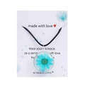 Detail shot of a handmade glass necklace featuring a real blue daisy flower inside the pendant - Blue