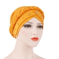 Detail of ginger yellow turban cap featuring braided design and golden bead accents - Turmeric