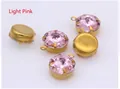 Macro detail of five light pink crystal pendants with gold metal four-prong settings - Light Pink