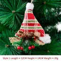 Mini cappello di Natale in maglia a quadri con pigne e bacche su un albero - Stile Cappello