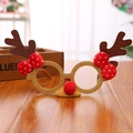 Close-up of festive Christmas reindeer antler glasses with brown glitter and red bow - Antler