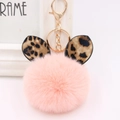 Detailed macro view of pink plush ball keychain with leopard print ears and gold metal ring - Gold Key Chain Style / Pink