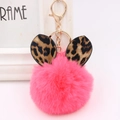 Close-up of fluffy magenta pompom keychain with leopard print ears and gold metal clasp - Gold Key Chain Style / Watermelon red