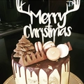 Detailed view of Merry Christmas cake topper with reindeer antlers on a chocolate cake - Antler Merry Christmas Style