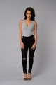 Jeans skinny neri strappati a vita alta da donna con un top grigio casual con scollo a V - S / Nero
