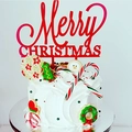 Macro shot of red Merry Christmas acrylic topper on a festive decorated holiday cake - Red Merry Christmas Style