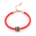Dettaglio del bracciale in corda rossa con ciondolo a cilindro in oro rosa e cristalli neri - Nero / Zirconia Nera