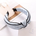 Light blue knotted fabric headband with black edge detail on a aesthetic background - Light Blue