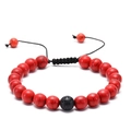 Macro detail of red turquoise-style beads and black lava stone on adjustable woven bracelet - Red Textured Beads with Single Volcanic Stone (No. 10)