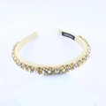 Close-up of handmade baroque headband with colorful rhinestones on champagne satin fabric - Beige