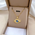 Detailaufnahme des Teufelsauge-Anhängers mit blauem Stein in einer Schmuckschatulle - Gold (Edelstahlkette Kupfer eingelegter Anhänger)
