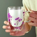 Hand holding double wall glass mug filled with milk and dried purple flowers - A-1123 / 350ml