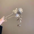 Macro detail of silver floral hair stick with tassel and 3D textured metal petals - Silver