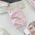Flat lay of pink shiny bow-textured drawstring storage bag for camera and accessories - Small Bow Pink