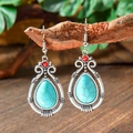 Detail view of Bohemian teardrop turquoise earrings hanging on a rustic wood stand - Teardrop Turquoise Contrast (HQEF-1960)