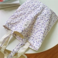 Detail shot of purple floral canvas tote bag featuring an ivory strap and chic woven label - Purple Background Pink White Floral