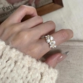 Elegante anello aperto con margherite bianche opache indossato da una modella - Stile tre fiori bianchi / Argento
