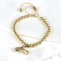 Close-up of golden beaded bracelet with rhinestone letter Y and adjustable clasp - Letter Y