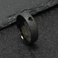 Matte black stainless steel ring with heart cutout on gray stone background - Black Hollow Heart (6mm)