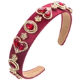 Detail van rode hartvormige haarband met gouden bloemenaccenten op stoffen basis - Rood