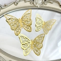 Three gold 3D hollow butterfly decorations with metallic finish on a vintage mirror - Style 1 / Gold